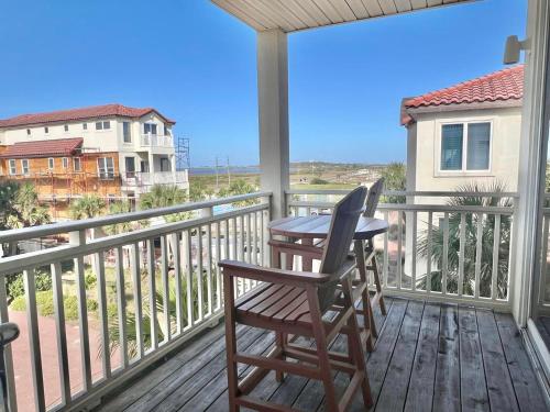 a porch with a table and chairs on a balcony at Cool Change- Sunset Beach- Beachfront- Pet-Friendly in St. George Island