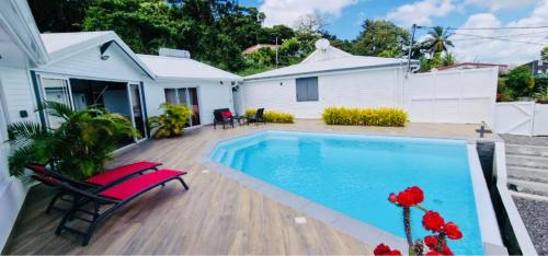 a backyard with a swimming pool and a house at La villa Tina in Ducos
