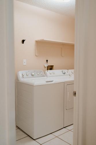 a white washer and dryer in a room at Luxury Private Pool Villa near Disney with Fire Pit, Game Room & More in Kissimmee