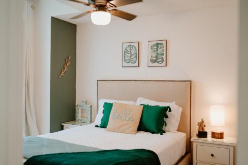 キシミーにあるLuxury Private Pool Villa near Disney with Fire Pit, Game Room & Moreのベッドルーム1室(緑と白の枕が備わるベッド1台付)