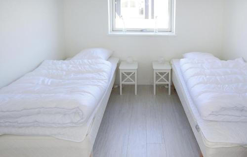 two beds in a room with white sheets and a window at Holiday Home Skovridervænget R Denmark in Spodsbjerg