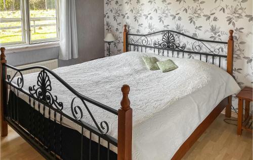 a bedroom with a black and white bed with a window at 3 Bedroom Lovely Home In Vittaryd in Kvänarp