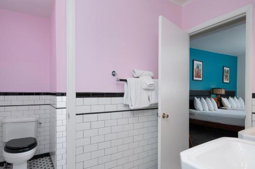 a bathroom with a toilet and a bed at Sapphire Motel Midtown Bozeman in Bozeman