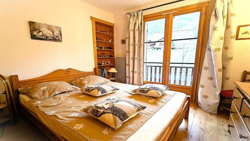 a bedroom with a bed and a large window at Résidence Le Belvedere - Chaleureux appartement T3 de 42 m²plein sud 4/6 personnes MAE-5231 in Pelvoux