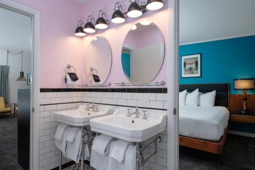a bathroom with two sinks and two mirrors at Sapphire Motel Midtown Bozeman in Bozeman