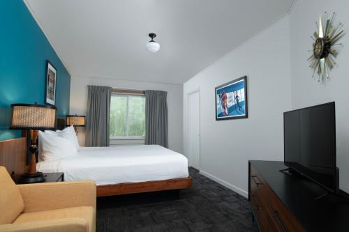 a hotel room with a bed and a tv at Sapphire Motel Midtown Bozeman in Bozeman