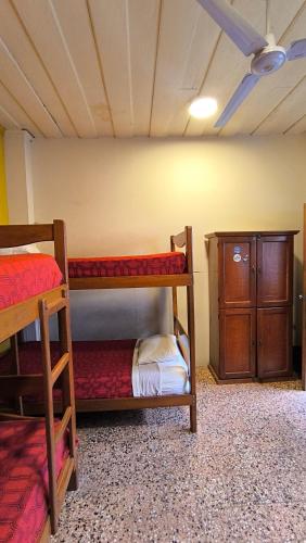 a room with two bunk beds and a cabinet at Flying Dog Hostel Iquitos in Iquitos