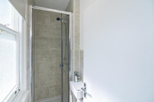 a bathroom with a shower and a sink at Beautiful House Refurbished in London