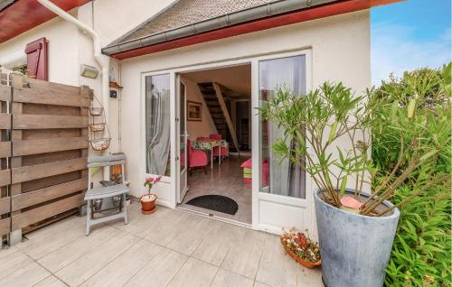 Une porte ouverte s'ouvre sur une terrasse avec une table et des chaises. dans l'établissement Nice Home In Le Minihic-Sur-Rance, à Le Minihic-sur-Rance
