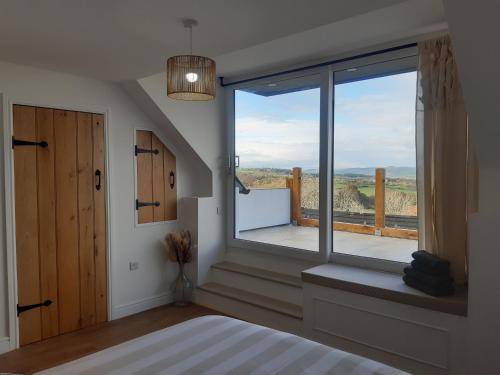 Schlafzimmer mit einem großen Fenster mit Aussicht in der Unterkunft Jasmine Cottage in Shrewsbury