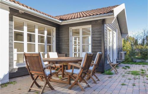 a patio with a wooden table and chairs at Holiday Home Hornbæk With Hot Tub Ix in Hornbæk