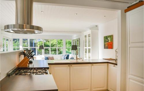 a kitchen with white cabinets and a stove top oven at Holiday Home Hornbæk With Hot Tub Ix in Hornbæk