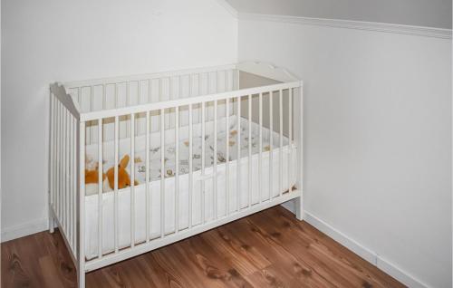 a crib in a room with white walls and wood floors at Nice Home In Gränna With Wifi in Gränna