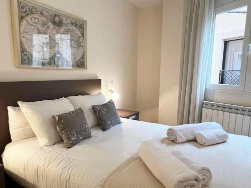 a bedroom with a bed with two towels on it at Apartamento Alma de Guadalajara with Sun terrace in Guadalajara