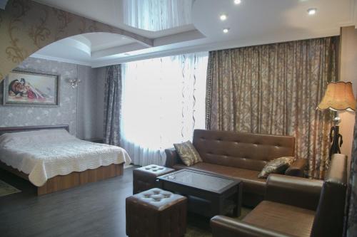 a bedroom with a bed and a couch and a bed and a room with at Hotel Yunost in Yekaterinburg