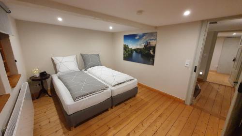 a bedroom with a bed with a painting on the wall at Wohnen im Denkmal in Niederbrechen