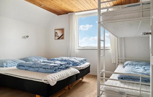 a bedroom with two bunk beds and a window at Nice Home In Ørum Djurs With Sauna in Nimtofte
