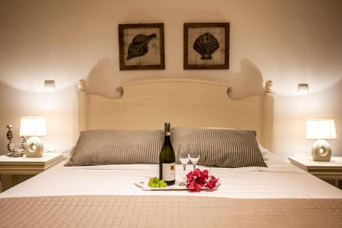 a bed with a bottle of wine and flowers on it at Villa Alyko in Aliko Beach