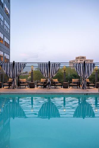 a pool with two umbrellas and chairs next to a building at Luxury Apartments by Hyatus at Pierpont in New Haven