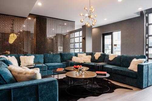 a living room with blue couches and a table at Luxury Apartments by Hyatus at Pierpont in New Haven