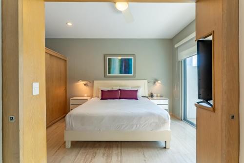 a bedroom with a bed and a flat screen tv at Papaya 15 Apartments in Playa del Carmen