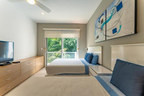 a bedroom with a bed and a large window at Papaya 15 Apartments in Playa del Carmen