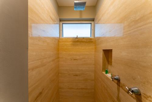 a bathroom with a shower with wooden walls and a window at Papaya 15 Apartments in Playa del Carmen