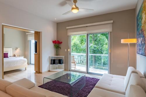 a living room with a white couch and a glass table at Papaya 15 Apartments in Playa del Carmen