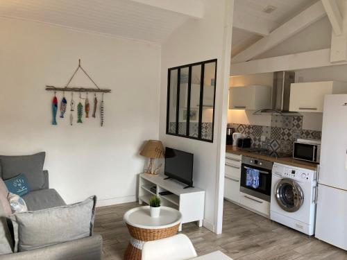 ein Wohnzimmer mit Couch und Küche in der Unterkunft Appartement Côté Bassin in Andernos-les-Bains