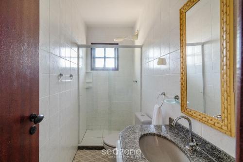 a bathroom with a sink and a shower with a mirror at Casa c/ Piscina na Praia da Dunas PDU0033 in Škorak