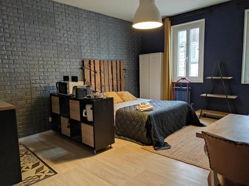 une chambre avec un lit et un mur de briques dans l'établissement Vintage studio Rouen Beauvoisine, à Rouen