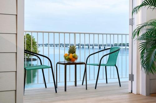 un balcón con 2 sillas y una mesa con fruta. en Casa La Costa By Wynwood House, en Panamá