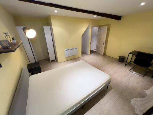 une chambre avec un lit blanc et un bureau dans l'établissement Chambre individuelle 4, à Ancerville