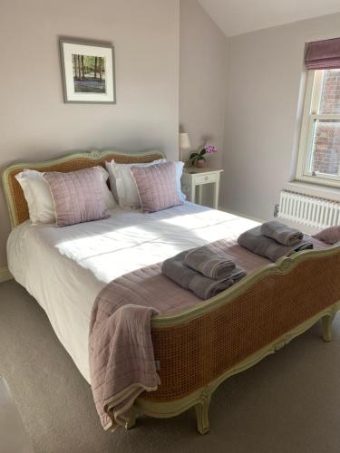 a large bed with pillows on it in a bedroom at Grooms Cottage by Sheriff Hutton Castle near York in Sheriff Hutton
