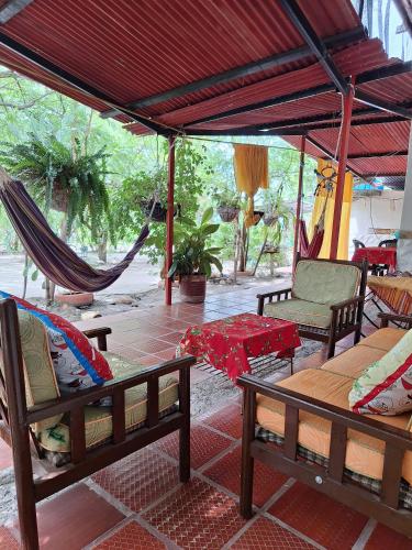 a patio with hammocks and chairs and a table at Alojamiento Casa de campo los Cactus in Villavieja