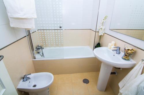 a bathroom with a sink and a bath tub at Apartamentos Centro Puerto de Santa Maria in El Puerto de Santa María