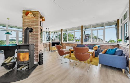 a living room with a fireplace and a brick wall at Holiday Home Ristingevej Humble Ii in Humble