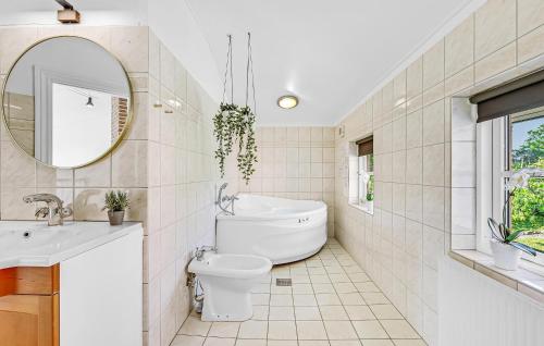 a bathroom with a toilet and a sink and a mirror at Holiday Home Ristingevej Humble Ii in Humble