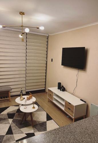 a living room with a flat screen tv on a wall at Costanera playa in Villarrica