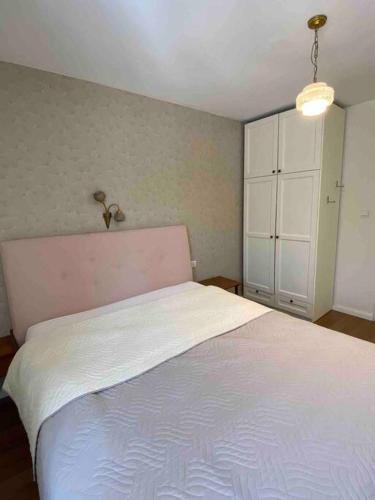 a bedroom with a white bed and a white cabinet at Beautiful, Central Emek Refaim Home in Yerushalayim