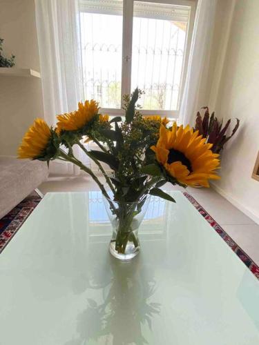 a vase filled with yellow flowers sitting on a table at Beautiful, Central Emek Refaim Home in Yerushalayim