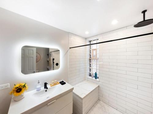 a white bathroom with a sink and a mirror at Chi-Town Ultimate Hideout 1-2-3 in Berwyn