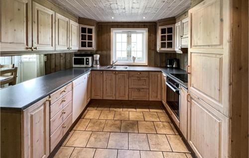 eine Küche mit Holzschränken und einer Arbeitsplatte in der Unterkunft Nice Home In Øyer With Sauna in Øyer