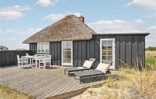 a black hut with a table and chairs on a deck at 3 Bedroom Gorgeous Home In Blåvand in Blåvand