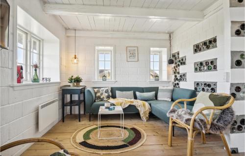 a living room with a blue couch and a table at 3 Bedroom Gorgeous Home In Blåvand in Blåvand