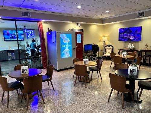 a dining room with tables and chairs and a tv at GreenTree Inn & Suites Los Angeles - Alhambra - Pasadena in Alhambra