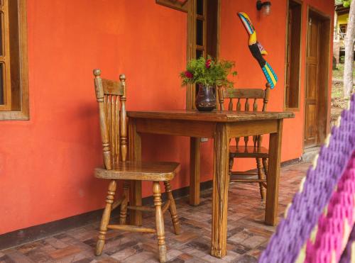 a wooden table with two chairs and a vase with flowers at Congos Lodge in El Perú