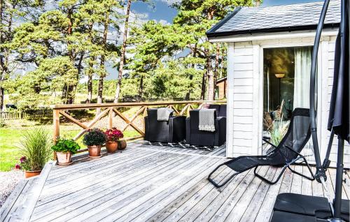 a wooden deck with chairs on a house at Cozy Home In Yngsjö With Kitchen in Yngsjö