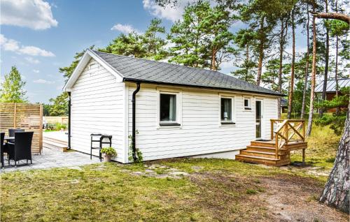 a white tiny house with a porch and a deck at Cozy Home In Yngsjö With Kitchen in Yngsjö