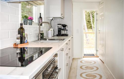 a kitchen with white countertops and a sink at Cozy Home In Yngsjö With Kitchen in Yngsjö